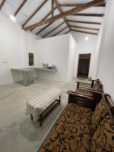 a room with two beds and a table in it at The luxy bay in Arugam Bay