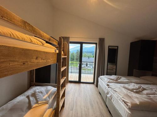 two bunk beds in a room with a balcony at Chalets Dualhaus, 2 Apartments mit Sauna, Nähe Pressegger See, Skibus zum Nassfeld in Hermagor