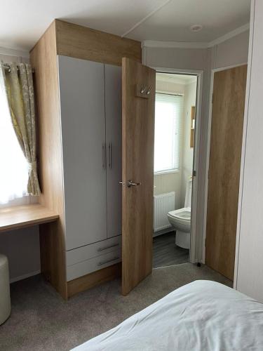 a bedroom with a large wardrobe and a toilet at Happy Holiday Seton Sands in Port Seton