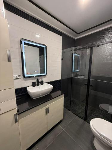 un baño con lavabo y ducha en Lujoso Apartamento, en Martil
