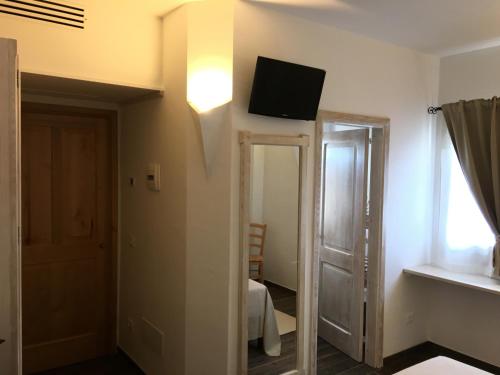 a room with a tv on the wall and a mirror at Monti di Jogliu in Arzachena