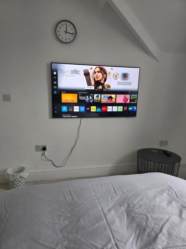 a flat screen tv on a wall above a bed at Shrewsbury in Manchester