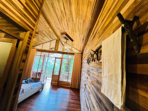 a room with a wooden wall in a cabin at Secret Mountain Paradise in Ella