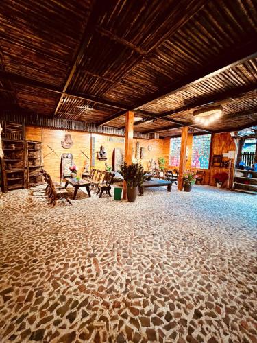 a large room with a stone floor with tables and benches at Pura homestay in Yên Minh