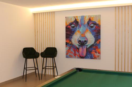 a pool table in a room with a painting of a dog at Untermairhof Appartment Residence in Selva dei Molini