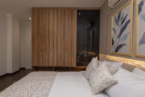 a bedroom with a white bed and a wooden cabinet at Marassi Views Direct on Pool 3BR Beach Access by Best of Bedz in El Alamein