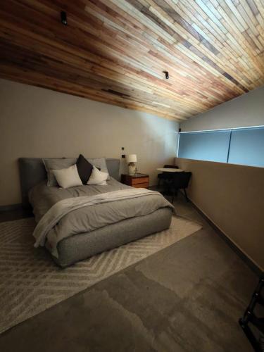 a bedroom with a bed and a wooden ceiling at Serenzzo Hotel & Cuisine in Tapalpa