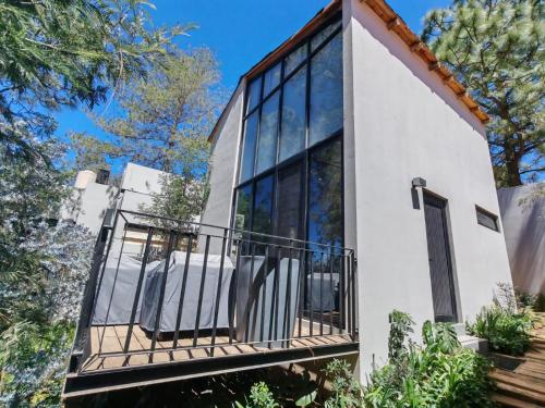 a house with glass windows and a balcony at Serenzzo Hotel & Cuisine in Tapalpa