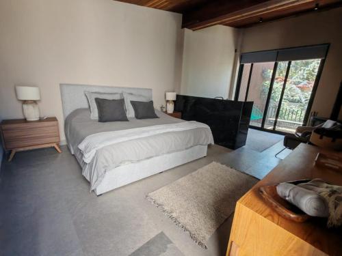 a bedroom with a large bed and a large window at Serenzzo Hotel & Cuisine in Tapalpa