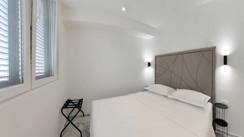 a white bedroom with a white bed and a window at Villa Bell'Aria Korcula in Vela Luka