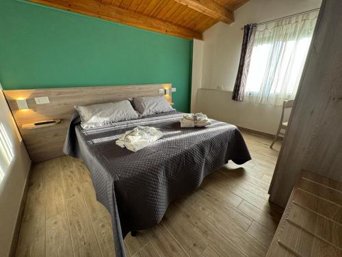 ein Schlafzimmer mit einem Bett und einer grünen Wand in der Unterkunft Come a Casa in Santa Maria del Cedro