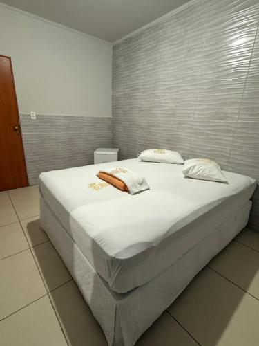 a bedroom with a large bed with white sheets at Hotel Real Jequie in Jequié