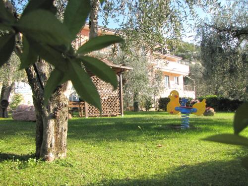 a yard with a tree and a playground at Residence Villa Margherita in Brenzone sul Garda