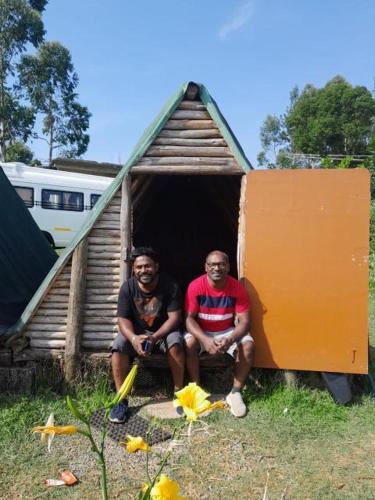 two men sitting inside of a small house at Farmers camp in Kanthalloor