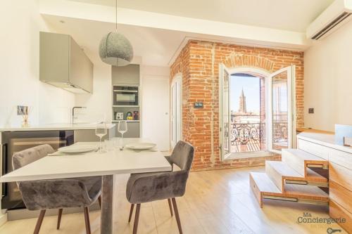 une cuisine et une salle à manger avec un mur en briques dans l'établissement Lorraine - Vue St-Sernin - Hypercentre - Capitole, à Toulouse