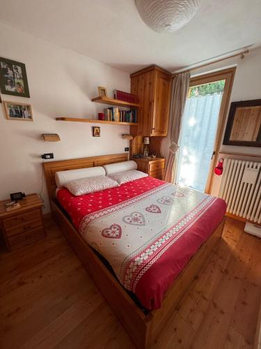 a bedroom with a large bed with a red blanket at Chalet CHIARA&CARLO in Bormio