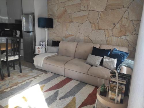 a living room with a couch and a stone wall at Casa do Fontanario em Viana do Castelo in Viana do Castelo