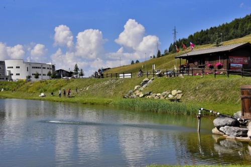 a body of water with a building on a hill at Shackleton Chalet in Sestriere