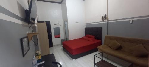 a living room with a bed and a couch at Krui penginapan jokowi in Krui