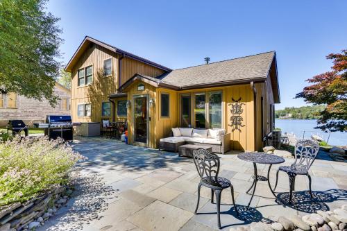a patio with chairs and a table in front of a house at Waterfront Home on White Lake Near Bethel Woods! in White Lake