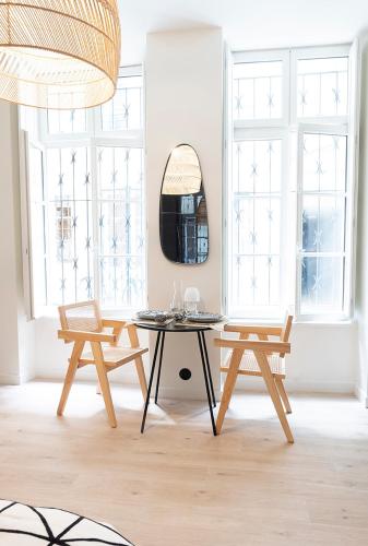 une pièce avec une table, deux chaises et un miroir dans l'établissement Studio élégant, à La Rochelle