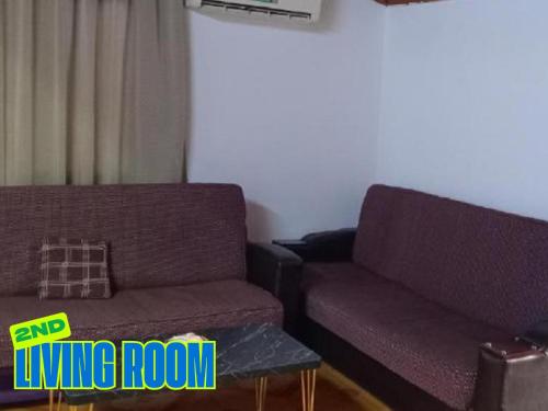 a living room with two purple couches and a coffee table at TOPO Hostel in Tirana