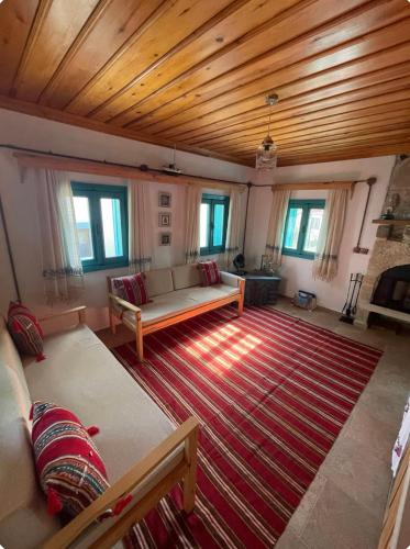 a living room with a couch and a rug at Gaba Dede Evleri-Bayram Evi in Cumalı