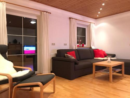 a living room with a couch and a tv at Kleinbergsonne in Filzmoos