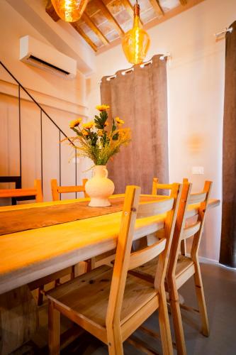 a dining room table with a vase of flowers on it at Loft di design Wi-Fi e Clima in Porto SantʼElpidio