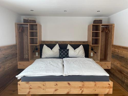 a bedroom with a large bed with wooden shelving at Kleinbergsonne in Filzmoos