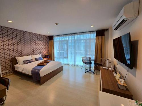 a hotel room with a bed and a television at The Beach Bangsaen Condo 327-23 in Ban Bang Saen (1)