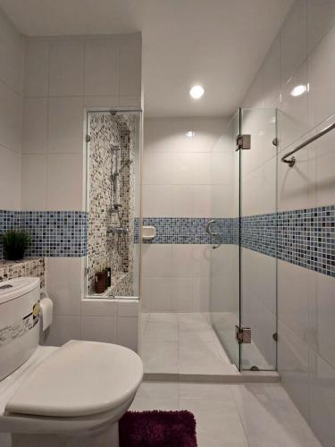 a bathroom with a toilet and a glass shower at The Beach Bangsaen Condo 327-23 in Ban Bang Saen (1)
