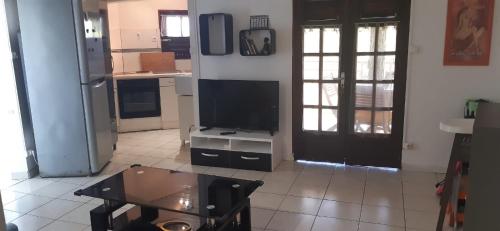a living room with a tv and a coffee table at Petit F2 en campagne au Vauclin in Le Vauclin