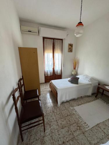 a bedroom with a bed and a chair and a window at Home Green in Mògoro