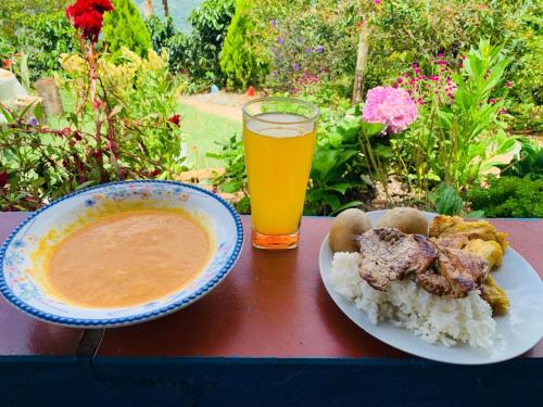 a table with a bowl of food and a glass of orange juice at Cabaña el sol in Titiribí