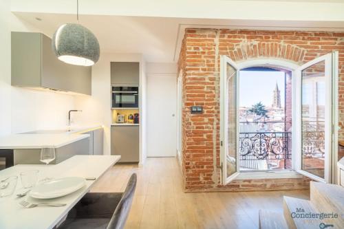 une cuisine avec un mur en briques et une fenêtre dans l'établissement Lorraine - Vue St-Sernin - Hypercentre - Capitole, à Toulouse