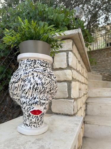 a black and white vase with a plant in it at Villa Annunziata Luxe in Aragona