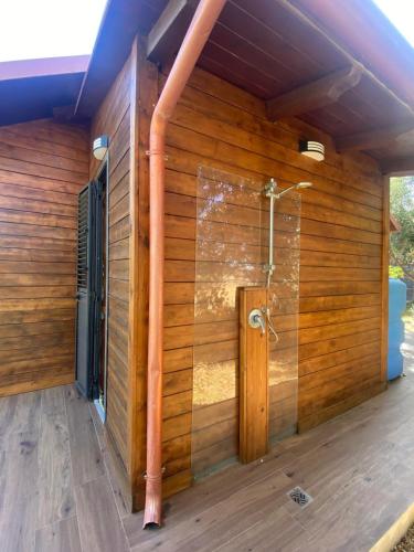 a bathroom with a shower in a wooden wall at Bungalow tra natura e mare in Capo Colonna