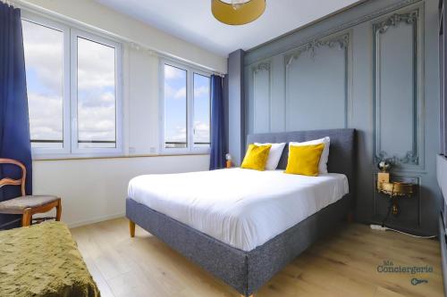 une chambre avec un grand lit avec des oreillers jaunes dans l'établissement Jaures - Vue panoramique sur la ville Rose, à Toulouse