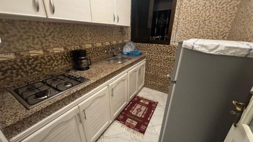 a small kitchen with a stove and a sink at Appartement plage kozah in Tangier