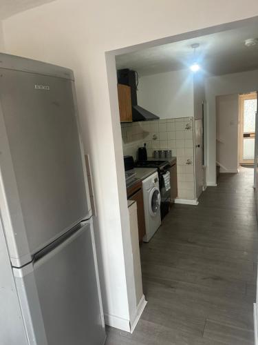 a kitchen with a stainless steel refrigerator in a room at Deluxe Large Double Room Near Basildon Town Centre in Basildon