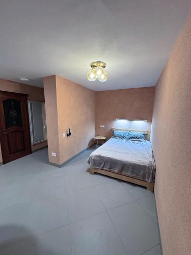 a bedroom with a bed and a light on the ceiling at Pilot House in Mykolaiv