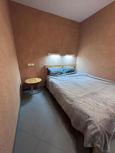 a bedroom with a bed and a small table at Pilot House in Mykolaiv