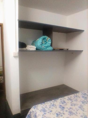 a corner of a room with a bed and shelves at Beny Cosy Studio in Rose Hill