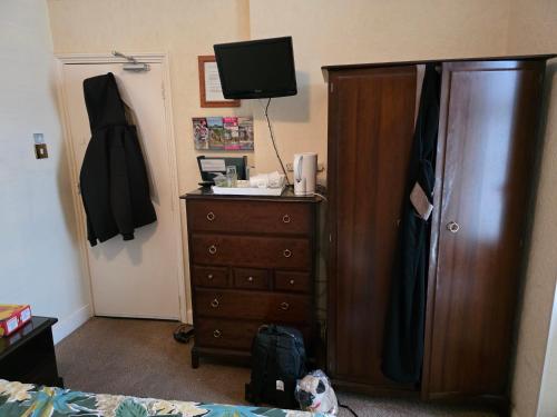 Un dormitorio con una cama y una cómoda con televisión. en Marina guest house, en Great Yarmouth