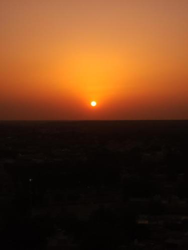 an orange sunset with the sun in the horizon at Diamond Guest House in Jaisalmer