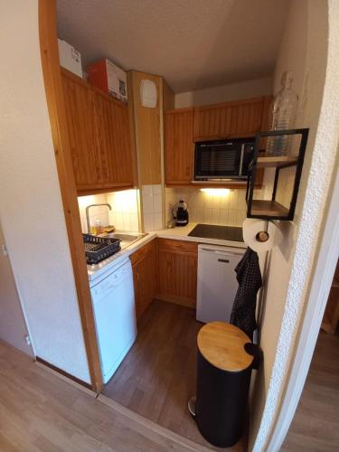 - une petite cuisine avec des placards en bois et des appareils blancs dans l'établissement Le Lou&My à Valmeinier 1800, à Valmeinier