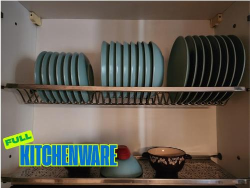 a row of green plates sitting on a shelf at TOPO Hostel in Tirana