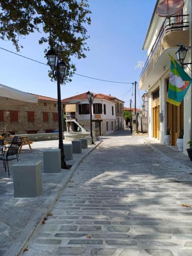an empty street with a flag and a building at Little square house in Argalasti