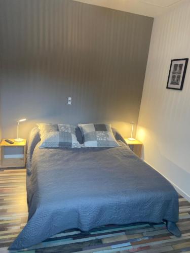 a bedroom with a large bed with two lamps at La maison de Rose, climatisé in Séguret